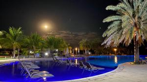 a pool with chairs and palm trees at night at Malai Manso Cotista - Resort Acomodações 8 hosp in Retiro