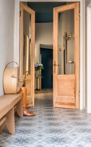 a hallway with a wooden door and a tiled floor at B&B l'histoire de l'éclair in Bruges