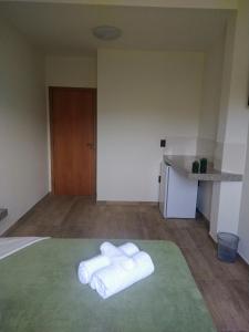 a room with three towels on a green rug at Suítes da Eu Florinha in Carrancas +72 photos