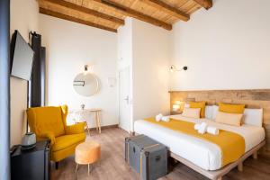 a bedroom with a large bed and a yellow chair at Dobo Azacanes Hostal in Toledo