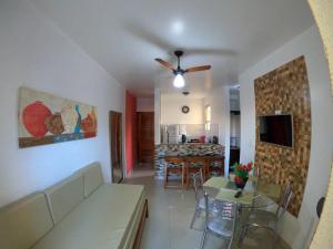 een woonkamer met een bank en een eetkamer bij Boulevard da Praia 124 B in Porto Seguro
