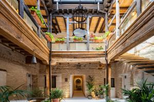 トレドにあるAzacanes Hostal Boutique Toledoの木製天井と植物のある大きな建物