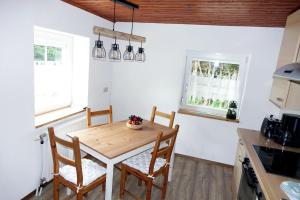 a kitchen with a wooden table and chairs at Haus Alpengluehn in Iselsberg