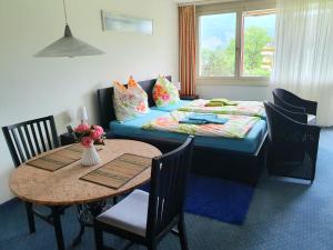 Cette chambre comprend un lit et une table avec des chaises. dans l'établissement priv. Apartment bei Swiss Holiday Park, à Morschach