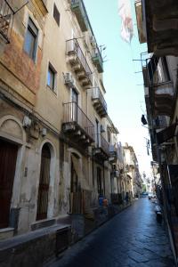 an empty street in a city with buildings at 4Tino in Catania