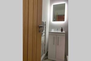 uma casa de banho com um lavatório branco e um espelho. em Sealladh Na Beinne -Mountain view em Caol