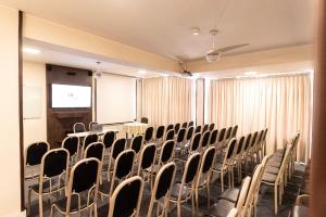 einen Konferenzraum mit Stühlen und einer Leinwand in der Unterkunft Hotel Fabris in Nova Friburgo