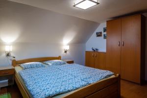 um quarto com uma cama com um edredão azul em Privat Mako em Trstené