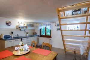 uma cozinha e sala de jantar com uma mesa e uma escada em Privat Mako em Trstené