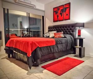 Acogedor monoambiente La Plata centro في لا بلاتا: غرفة نوم بسرير كبير مع بطانية حمراء