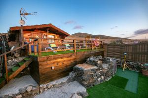 a log cabin with a deck and a patio at La Maxada Luz Maria in Cotillo