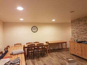 una cocina con mesa y sillas y un reloj en la pared en Casa Lys, en Hauterives