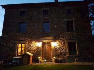 Casa de piedra con puerta de madera por la noche en Casa Lys, en Hauterives