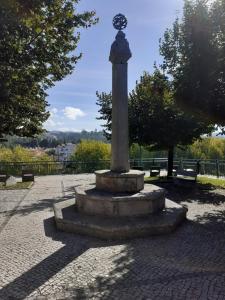 a stone monument with a clock on top of it at Largo da Fonte in Sertã