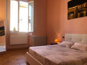 een slaapkamer met een groot bed en een raam bij 3 Perle all'Accademia Apartments in Florence