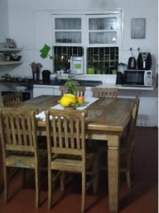 a kitchen with a wooden table and chairs in a kitchen at Quarto em casa compartilhada in Florianópolis