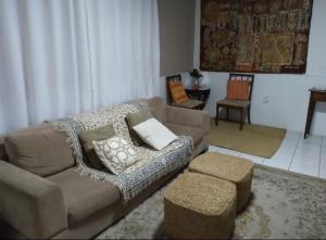 a living room with a couch and a table at Quarto em casa compartilhada in Florianópolis