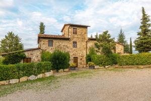 a large stone house with bushes and trees at Ulivo in Radda in Chianti