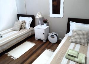 1 dormitorio con 2 camas individuales y mesita de noche en Quarto em casa compartilhada, en Florianópolis