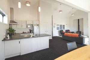 an open kitchen and a living room with a couch at Cass Crib - Lake Tekapo in Lake Tekapo