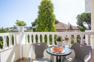 a table on a balcony with two chairs and a bowl of fruit at Economisa Apartments in Ialysos