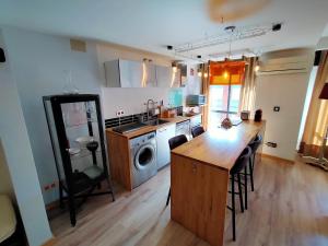 a kitchen with a table and a kitchen with a washing machine at Loft Montaña Central in Aller