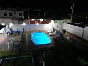 una piscina su una terrazza di notte di Pousada Aldeia do Sossego a Santa Cruz Cabrália