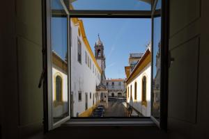 a view from a window of a street with a clock tower at Casa do Povo in Elvas
