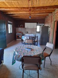 Habitación con mesa, sillas y cocina. en Sol del Este en Alto de Sierra