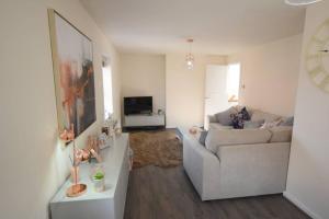 a living room with a couch and a television at The Coach House in Kirby Muxloe