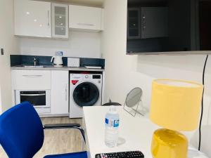 uma cozinha com uma mesa e cadeiras e uma máquina de lavar roupa em NEW MODERN STUDIO APARTMENT, PARKING, Netflix em Kenilworth