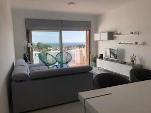 ein Wohnzimmer mit einem Sofa und einem großen Fenster in der Unterkunft Beach House Cabedelo in Viana do Castelo