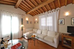 a living room with a white couch and a table at Il Sole in Gaiole in Chianti