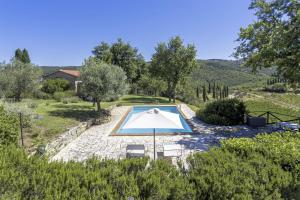 einen Blick über den Pool im Garten in der Unterkunft Ginestra in Castellina in Chianti