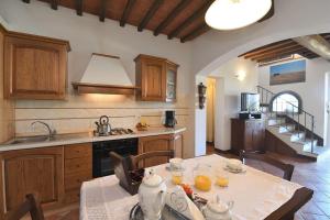 a kitchen with a table with chairs and a kitchen with a sink at Paglia in SantʼAppiano