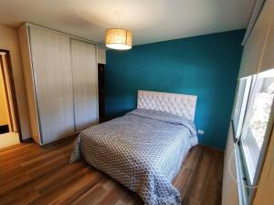a bedroom with a bed and a blue wall at la elegida in Mar Azul
