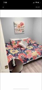 um quarto com uma cama com uma colcha floral e uma mesa em Nice bedroom next fells point em Baltimore