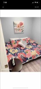 a bedroom with a bed with a floral bedspread and a table at Nice bedroom next fells point in Baltimore