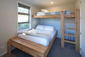 a bedroom with two bunk beds and a ladder at Bivouac - Lake Tekapo in Lake Tekapo