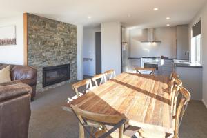 a living room with a wooden table and a fireplace at Bivouac - Lake Tekapo in Lake Tekapo