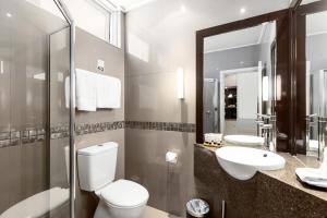 a bathroom with a toilet and a sink and a mirror at The Commodore in Mount Gambier