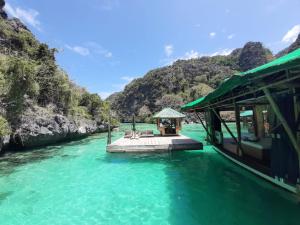 a boat in the water next to a river at Paolyn Houseboats Coron Island in Coron