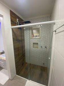eine Dusche mit Glastür im Bad in der Unterkunft Suíte da Cris em Gramado in Gramado