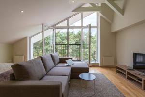 a living room with a couch and a large window at Parnidžio Kopa in Nida