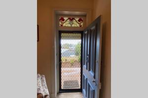 an open door with a gate and a window at Kitty Spain's Cottage in Mannum