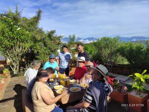 EcoHotel Barichara في باريكارا: مجموعة من الناس يجلسون حول طاولة الأكل