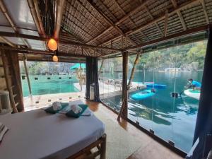 a bedroom with a bed and a view of a pool at Paolyn Houseboats Coron Island in Coron