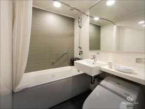 a bathroom with a sink and a tub and a toilet at Daiwa Roynet Hotel Sapporo-Susukino in Sapporo