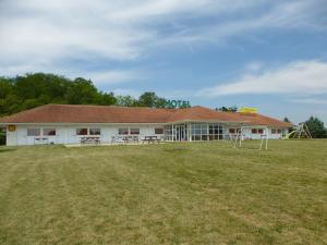 un edificio con un gran campo delante de él en Fasthotel Well Inn Mâcon sud - un hôtel FH Confort, en Charnay-lès-Mâcon