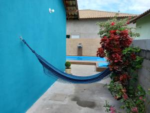a hammock attached to a building with a bench and flowers at Vivamar2 in Cabo Frio